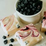 blueberry and cream fudge arranged around a bowl of blueberries