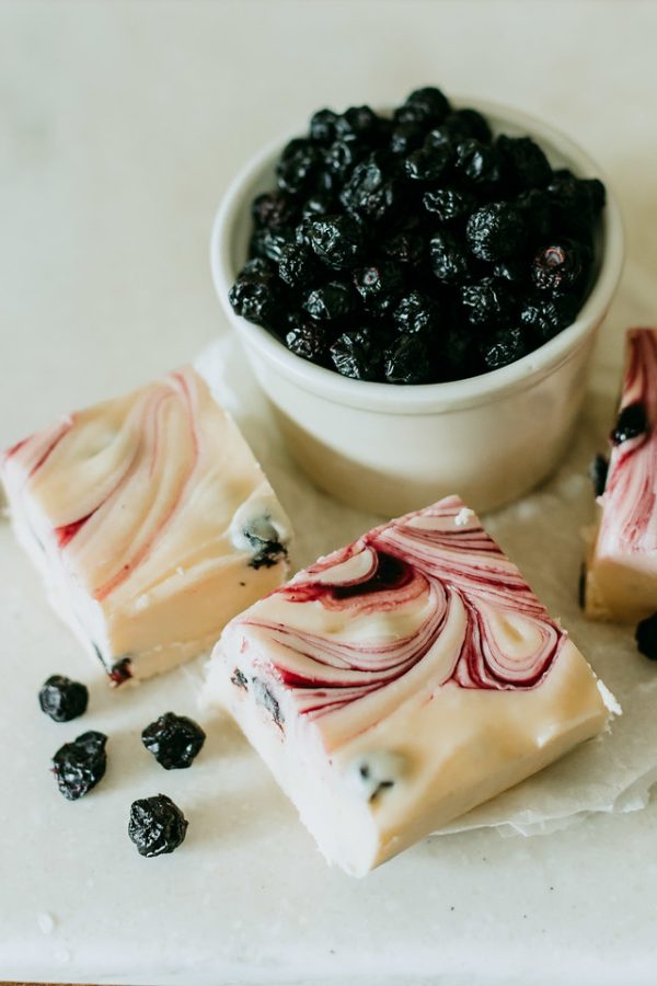 blueberry and cream fudge arranged around a bowl of blueberries