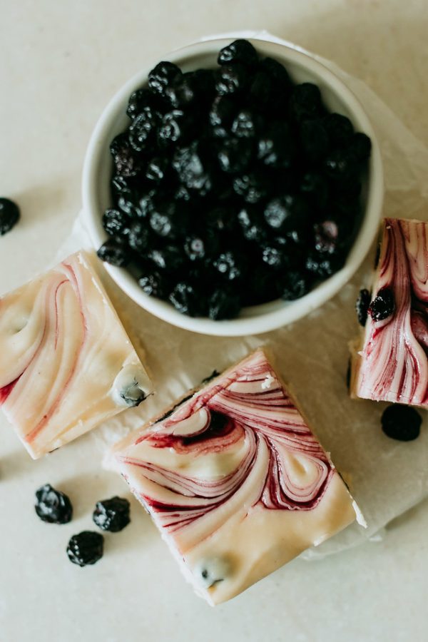 blueberry and cream fudge arranged around a bowl of blueberries