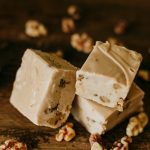 maple walnut fudge with maple soaked walnuts scattered around