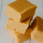 squares of pumpkin fudge stacked on a wood table