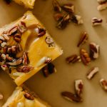 row of pumpkin praline fudge squares surrounded by nuts